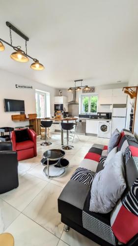 un salon avec un canapé et une cuisine dans l'établissement PN 84, Maison 4-6 personnes , jardin , plage et centre ville à 15 min à pied, à Houlgate