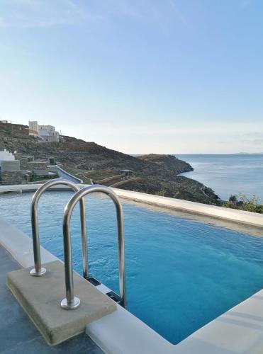 a swimming pool with a view of the ocean at Tinos Portraits Ballos in Agios Romanos