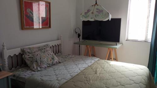 1 dormitorio con 1 cama y TV de pantalla plana en Coty's Beach, en Benalmádena
