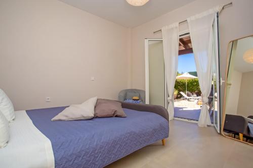 アギオス・ゲオルギオスにあるCosmos Villas Angelinaのビーチの景色を望むベッドルーム1室(ベッド1台付)が備わります。