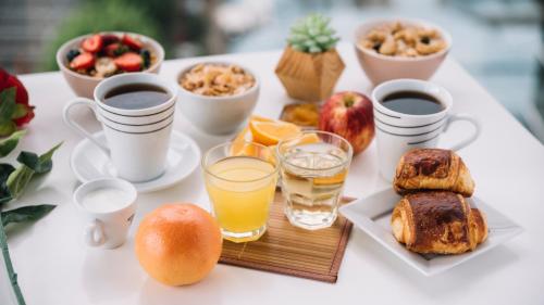 - une table blanche avec des aliments et des boissons pour le petit-déjeuner dans l'établissement Mas Gran de Cruïlles - Mas Rural - Hotel & Events, à Cruïlles
