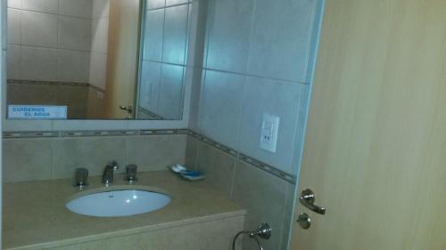 y baño con lavabo y espejo. en Hotel Vesubio II en Villa Gesell