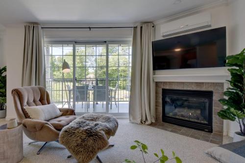 a living room with a chair and a fireplace at La Halte Mont-Blanc Ski in out in Saint-Faustin
