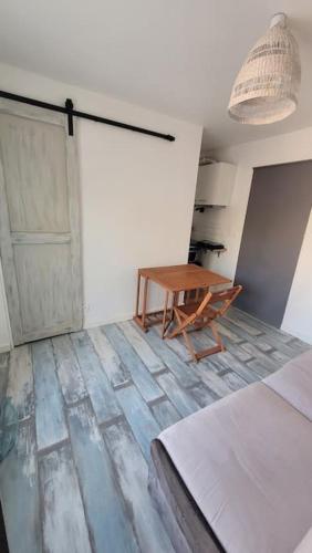 Cette chambre comprend un lit, une table et une porte. dans l'établissement studio avec extérieur, à Solliès-Toucas