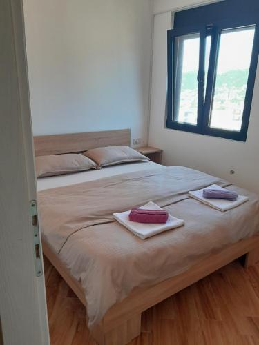 a bedroom with a large bed with two towels on it at Dubrava Czarnogóra in Dobra Voda