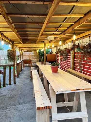a row of wooden tables in a patio at Cabaña La campana in Hijuelas