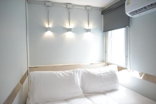 een slaapkamer met een bed met verlichting erboven bij KENCOZY accommodation in Bangkok