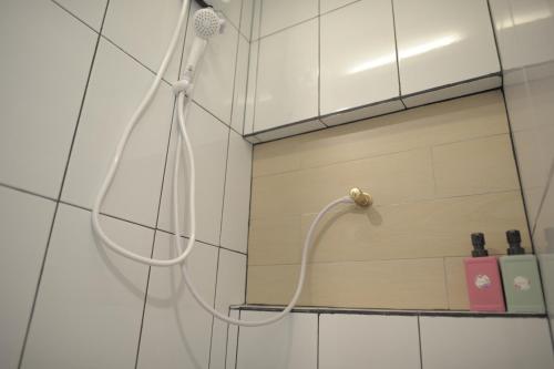 a shower with a hose in a bathroom at KENCOZY accommodation in Bangkok