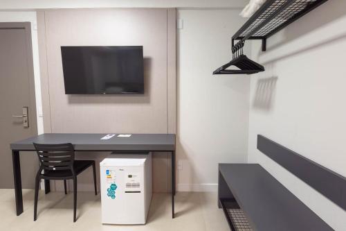 a room with a table with a chair and a tv at Rede Andrade Cecomtur in Florianópolis