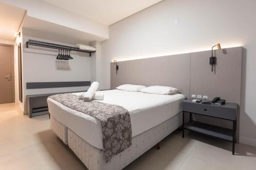 a bedroom with a large white bed in a room at Rede Andrade Cecomtur in Florianópolis