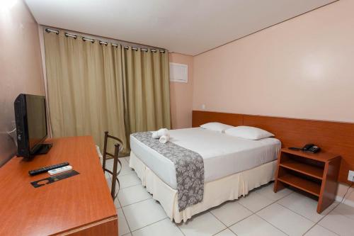 a hotel room with a bed and a television at Rede Andrade Cecomtur in Florianópolis
