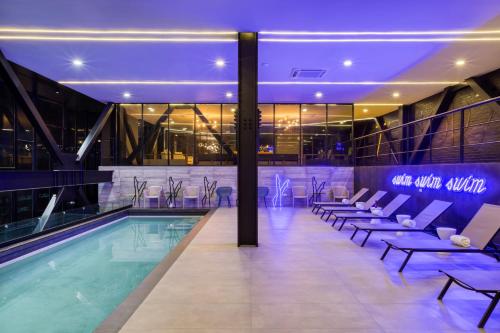 a hotel pool with lounge chairs and a swimming pool at Downtown Designer Apartments by ULIV in Tijuana
