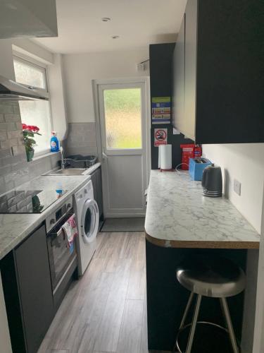 a small kitchen with a stove and a dishwasher at Standard Double Room near OVO Wembley Stadium in London