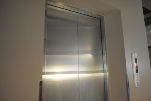 a stainless steel closet with lights on the wall at KENCOZY accommodation in Bangkok