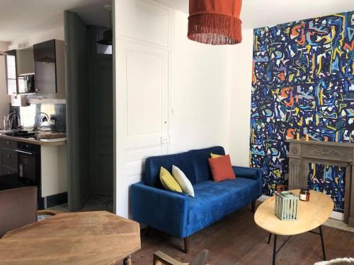 un salon avec un canapé bleu et une table dans l'établissement L'Escale paimpolaise, à Paimpol