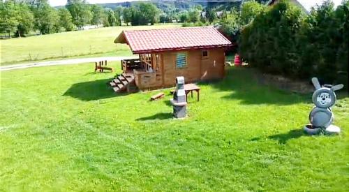 eine kleine Hütte mitten auf einem grünen Feld in der Unterkunft Domek nad Olszanka in Olszanica