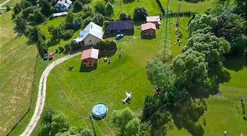 Eine Gruppe von Menschen auf einem Feld mit einem Haus in der Unterkunft Domek nad Olszanka in Olszanica