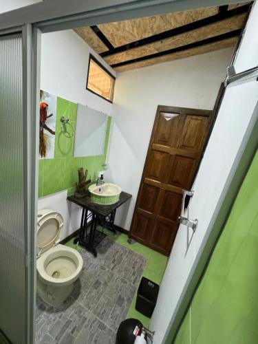 a bathroom with a toilet and a sink at Eco Hotel Birdland en Buga Valle in Buga