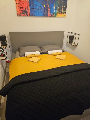 a bedroom with a bed with a yellow blanket at Mali Raj - self check in in Osijek