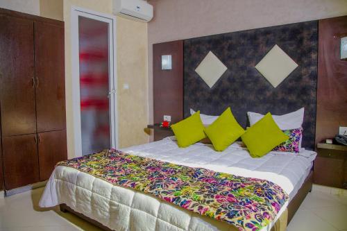 a bedroom with a large bed with colorful pillows at Hotel Vents Des Iles in Essaouira
