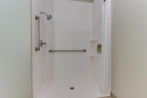 a shower in a bathroom with a white wall at Holiday Inn Express Hotel & Suites Corbin by IHG in Corbin