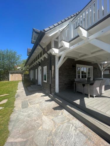 eine Terrasse eines Hauses mit einem Tisch darauf in der Unterkunft Bay Cottage wynajem domków in Swarzewo