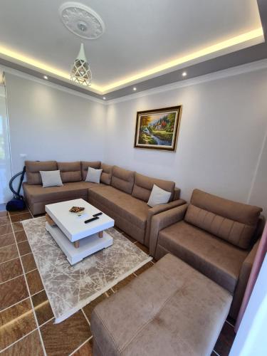 a living room with a couch and a table at Modern Apartment by the Beach Fishta Q5 23 in Velipojë