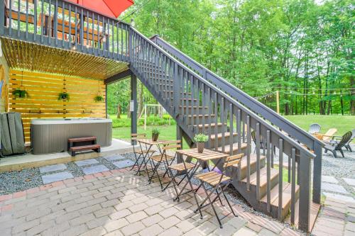 a patio with a staircase and tables and chairs at 5 Mi to Lake Naomi Home with Hot Tub and Fire Pit in Long Pond