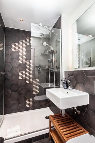 a bathroom with a sink and a shower at Hôtel Vendome Saint-Germain in Paris