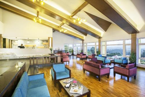 a dining room with tables and chairs and windows at Sterling Ooty Elk Hill in Ooty