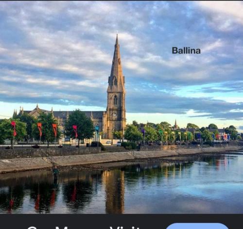a building with a clock tower next to a river at Mountain View in Skreen