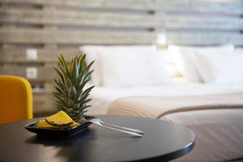 een bord eten op een tafel met een ananas bij Athina résidence in Nydri