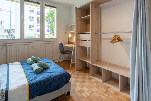 une chambre avec un lit, un bureau et une fenêtre dans l'établissement Appartement rénové pour 6 avec parking, à Villeurbanne
