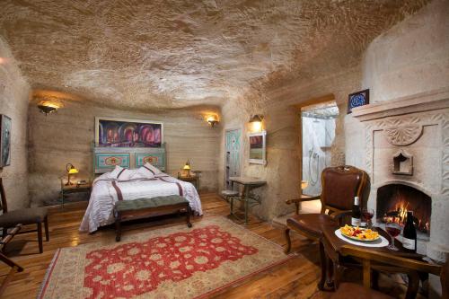 a bedroom with a bed and a fireplace at Terra Cave Hotel in Goreme