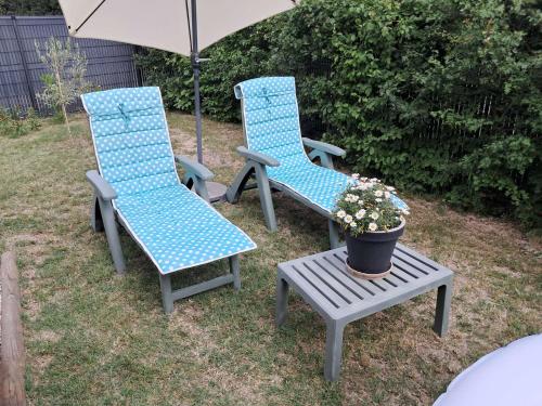 two chairs and a table with a potted plant and an umbrella at Chambre hôtes jacuzzi climatiseur provence in Tulette