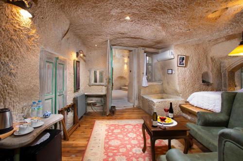 a living room with a couch and a bed and a tub at Terra Cave Hotel in Goreme