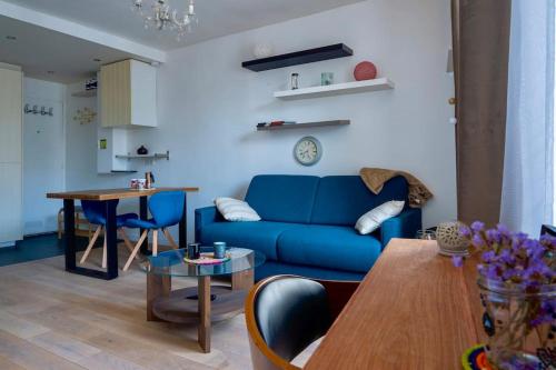 un salon avec un canapé bleu et une table dans l'établissement Appartement moderne proche Gare de Lyon, à Paris