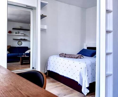 une chambre avec un lit, une table et un miroir dans l'établissement Appartement moderne proche Gare de Lyon, à Paris