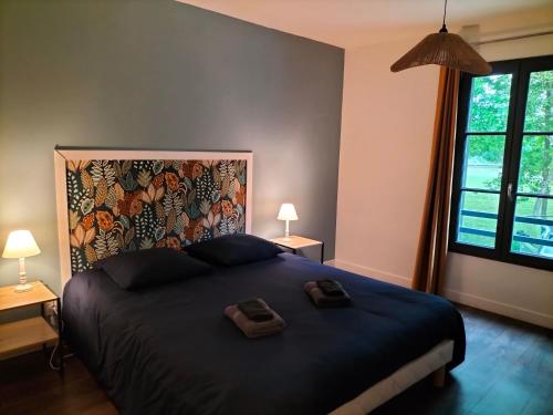 a bedroom with a large bed with two towels on it at Le refuge de Loire in Montrelais