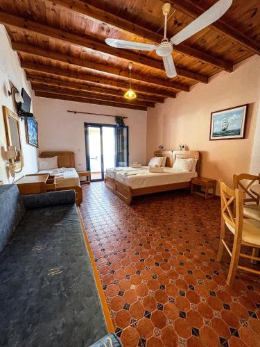 a large room with two beds and a ceiling at The Blue House in Loutro