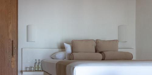 a white bedroom with a bed and a chair at Suites Panamera in Tulum