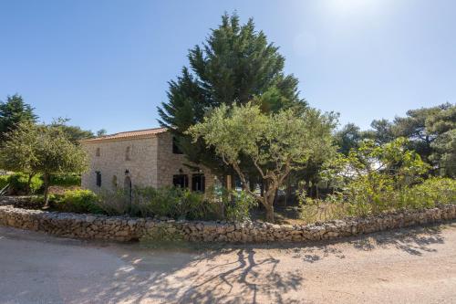 a stone retaining wall in front of a house at Aresti Mountain Resort in Agios Leon