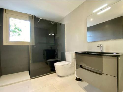 a bathroom with a toilet and a sink and a shower at Vistamar in Les tres Cales
