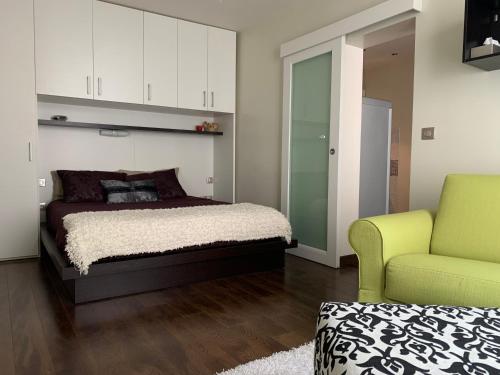 - une chambre avec un lit et une chaise verte dans l'établissement Un nido a Versailles, à Versailles