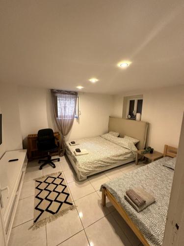 - une chambre avec 2 lits et une chaise dans l'établissement Jolie appartement Nice proche mer et aéroport Une chambre plus salon avec cuisine, à Nice