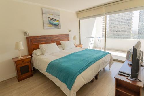a bedroom with a bed and a television and a window at Kennedy Premium Apartments in Santiago