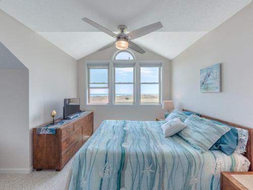 a bedroom with a bed and a ceiling fan at Slow Motion #8A in Topsail Beach