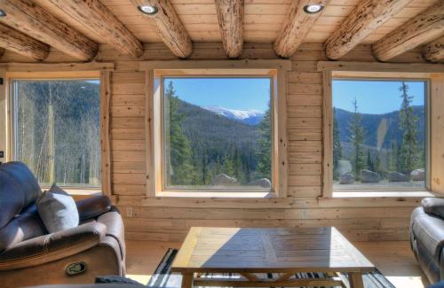 a room with two couches and a table and two windows at Amethyst Hideaway in Creede