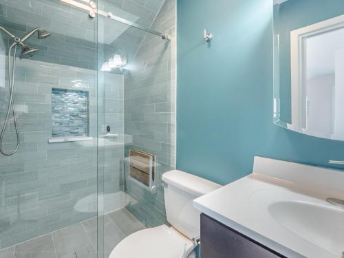 a bathroom with a toilet and a glass shower at Slow Motion #8A in Topsail Beach
