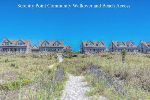 a row of houses on a beach with a path at Slow Motion #8A in Topsail Beach